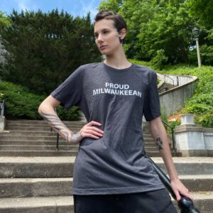 Woman modeling a "Proud Milwaukeean" t-shirt while standing on the steps of the Lake Park Grand Staircase.